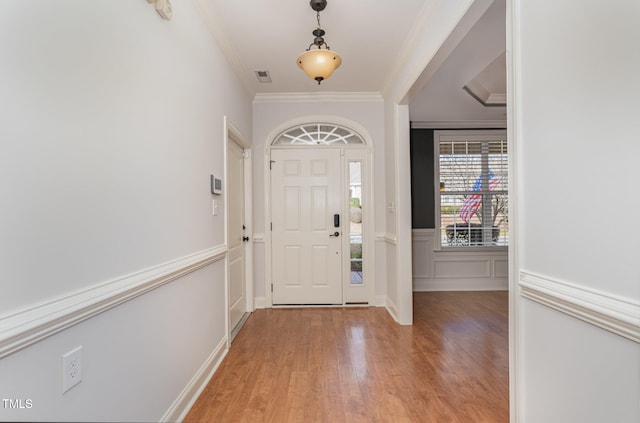 entryway featuring light wood-type flooring and ornamental molding