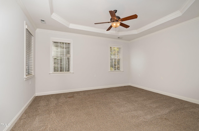 carpeted spare room with ceiling fan, crown molding, and a tray ceiling