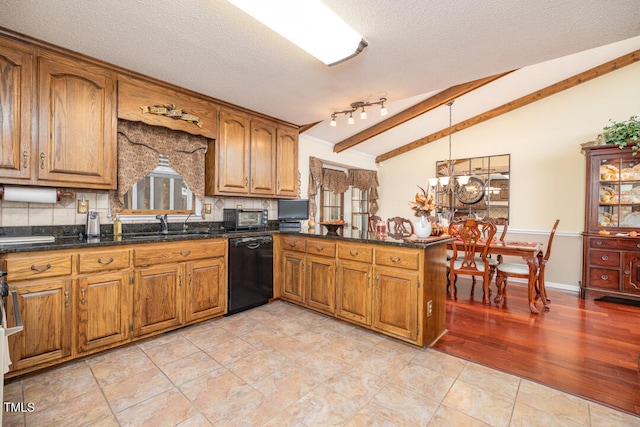 kitchen with pendant lighting, vaulted ceiling with beams, black dishwasher, a textured ceiling, and kitchen peninsula