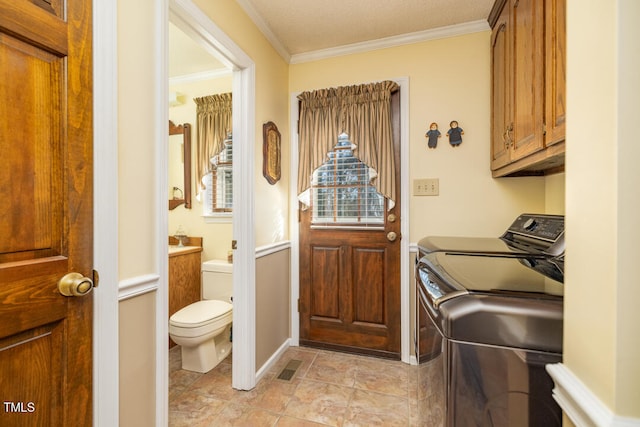 washroom with cabinets, independent washer and dryer, and crown molding