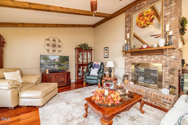 living room with a fireplace, hardwood / wood-style flooring, ceiling fan, and beamed ceiling