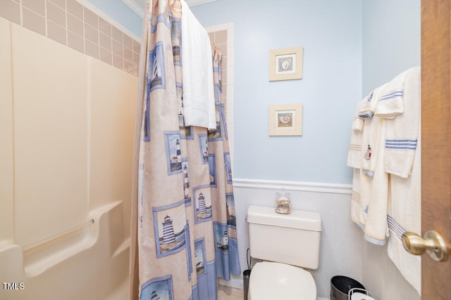 bathroom with curtained shower and toilet