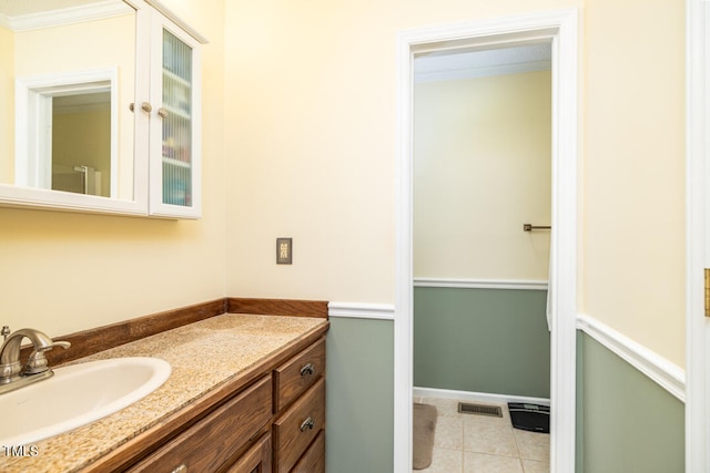 bathroom featuring tile patterned flooring, vanity, and crown molding