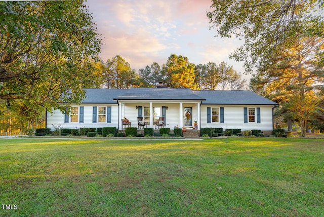 ranch-style house with a porch and a yard