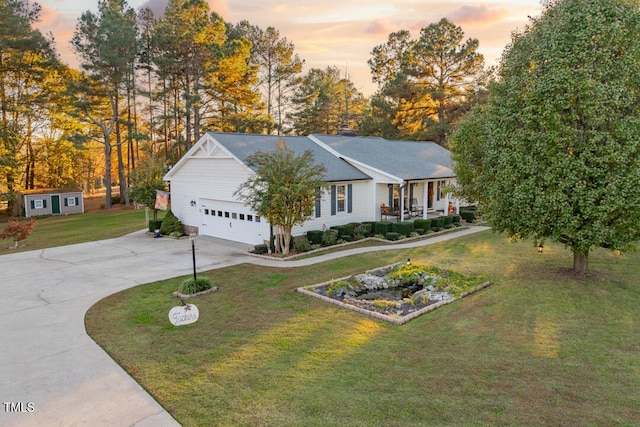 ranch-style home featuring a yard, a porch, and a garage