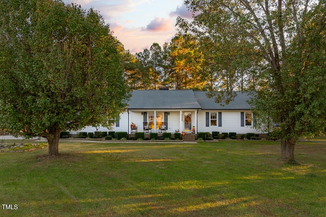 view of front of house with a lawn and a porch