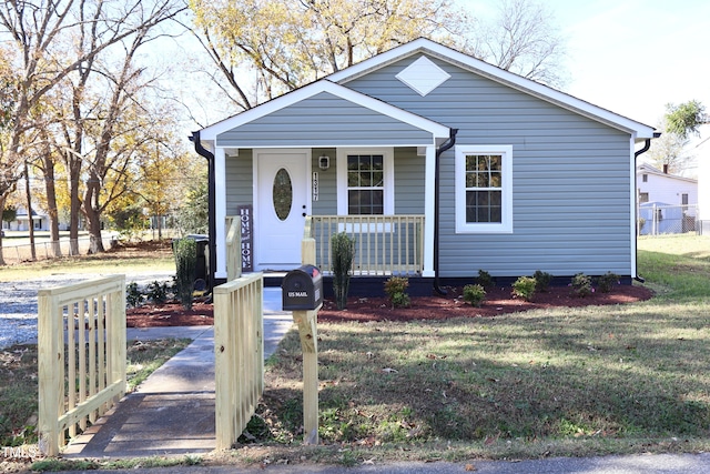 bungalow-style house featuring a front lawn and covered porch