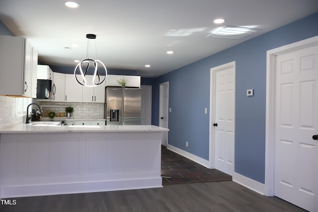 kitchen featuring stainless steel refrigerator with ice dispenser, dark hardwood / wood-style flooring, decorative light fixtures, white cabinets, and range