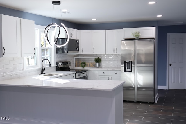 kitchen featuring kitchen peninsula, appliances with stainless steel finishes, white cabinetry, and pendant lighting