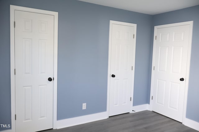 unfurnished bedroom with dark wood-type flooring