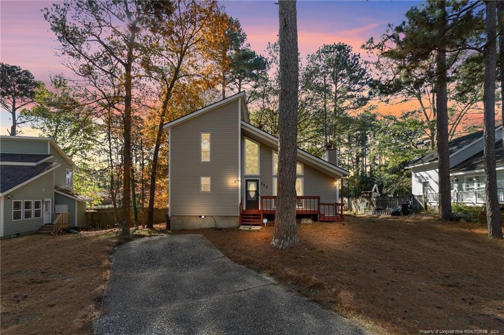 property exterior at dusk with a wooden deck