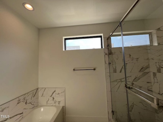 bathroom featuring independent shower and bath