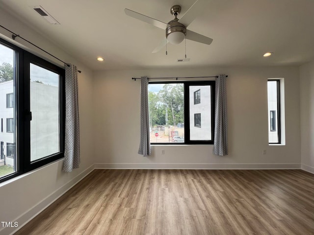 unfurnished room featuring light hardwood / wood-style flooring, a wealth of natural light, and ceiling fan