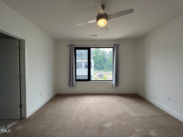 carpeted spare room featuring ceiling fan