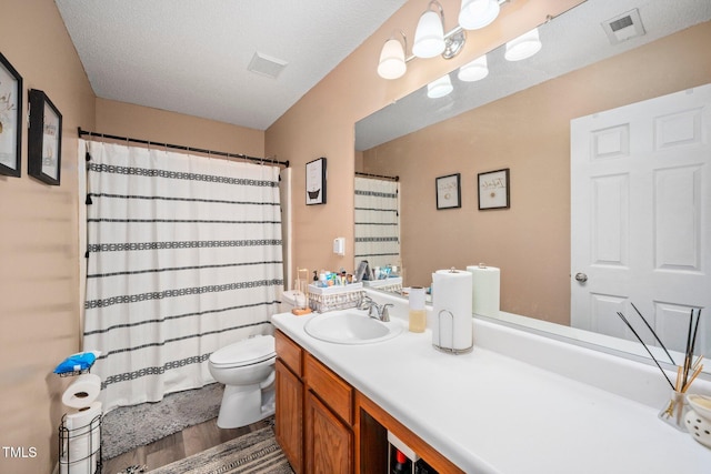 bathroom with hardwood / wood-style flooring, vanity, toilet, and a textured ceiling