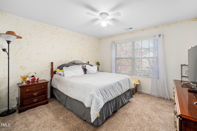 carpeted bedroom featuring ceiling fan and a textured ceiling