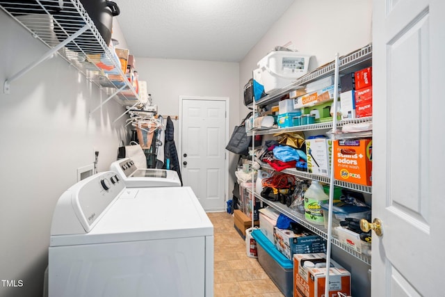 washroom with a textured ceiling and washing machine and clothes dryer