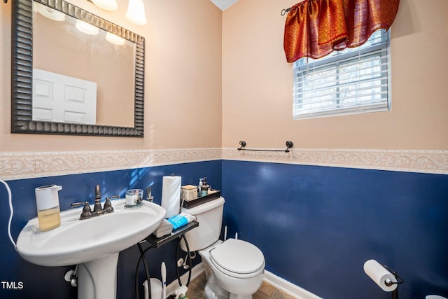 bathroom with toilet and tile walls