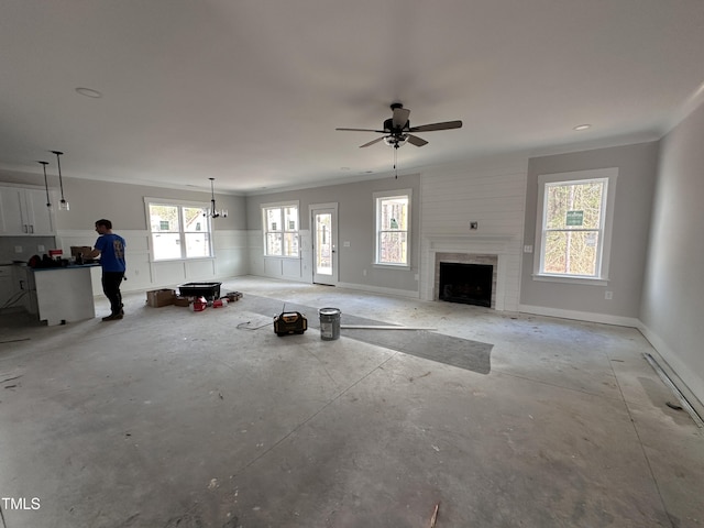 unfurnished living room featuring baseboards, concrete flooring, and ornamental molding