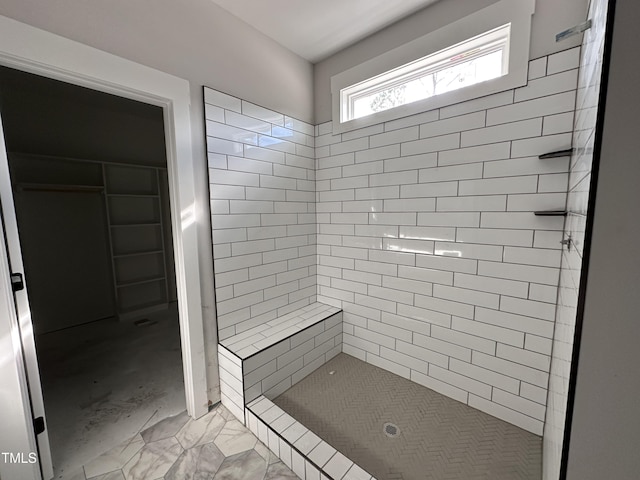 full bath with a stall shower, a spacious closet, and marble finish floor