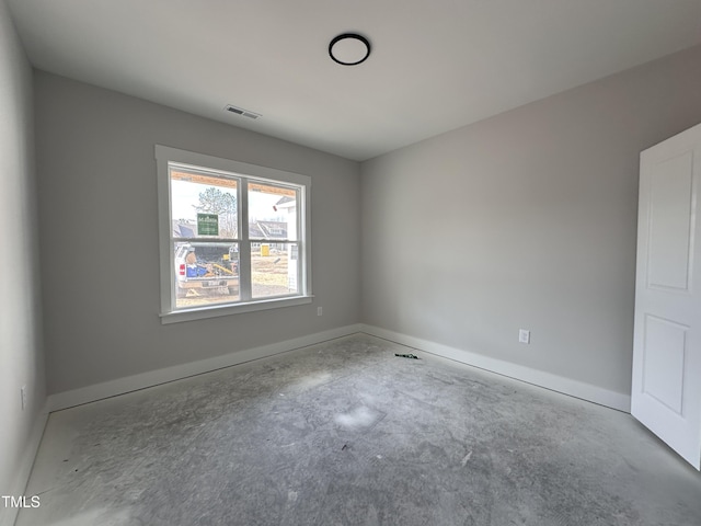 unfurnished room with baseboards, concrete floors, and visible vents