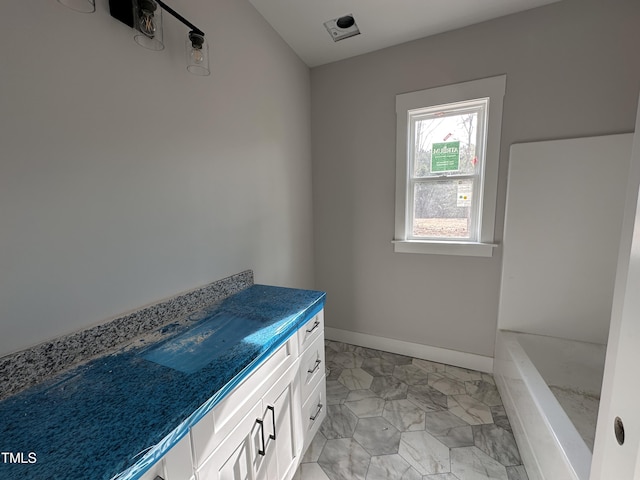 bathroom featuring a tub and baseboards