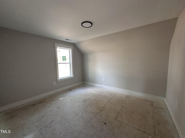 bonus room featuring lofted ceiling, visible vents, and baseboards