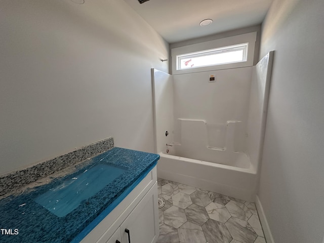 bathroom featuring marble finish floor, shower / bath combination, vanity, and baseboards