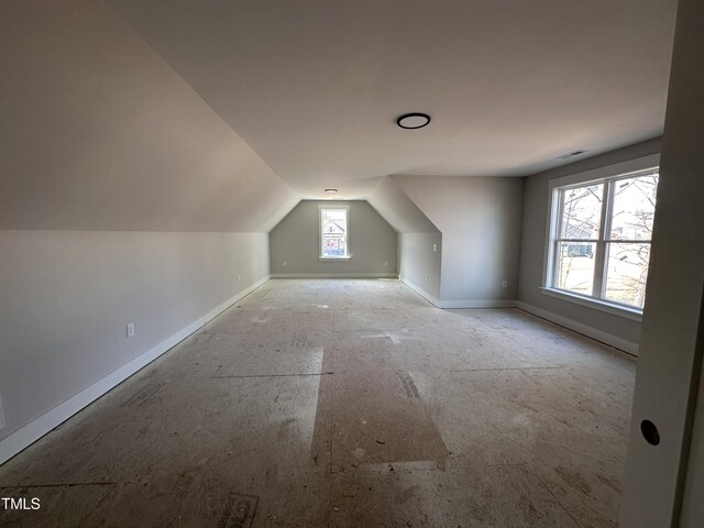 additional living space featuring lofted ceiling and baseboards