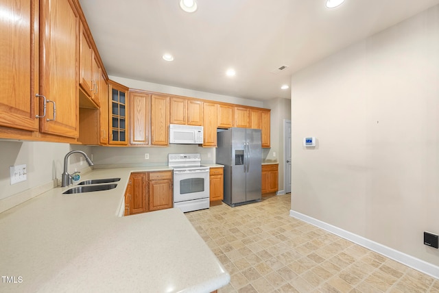 kitchen with kitchen peninsula, white appliances, and sink