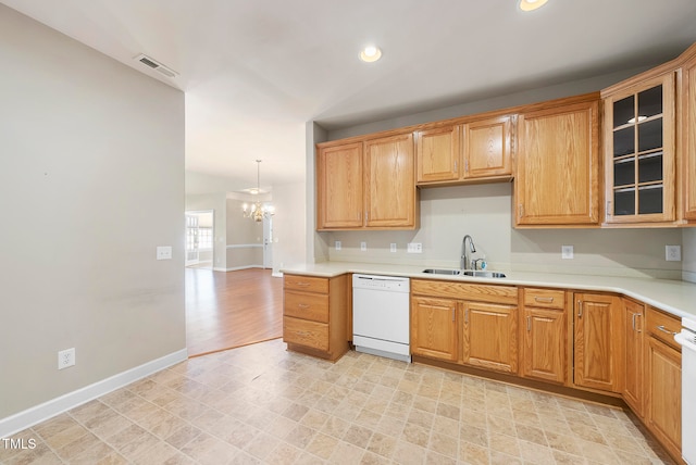 kitchen featuring a notable chandelier, white appliances, sink, and hanging light fixtures