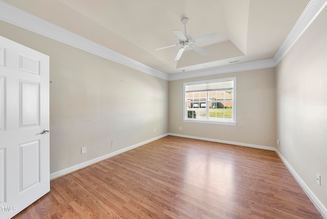 unfurnished room with hardwood / wood-style floors, ceiling fan, a raised ceiling, and ornamental molding