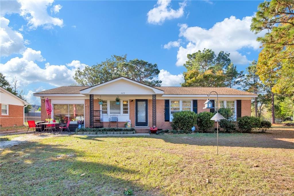 single story home featuring a porch and a front yard