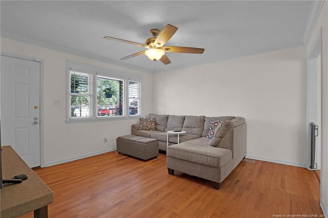 living room featuring ceiling fan, wood-type flooring, and ornamental molding