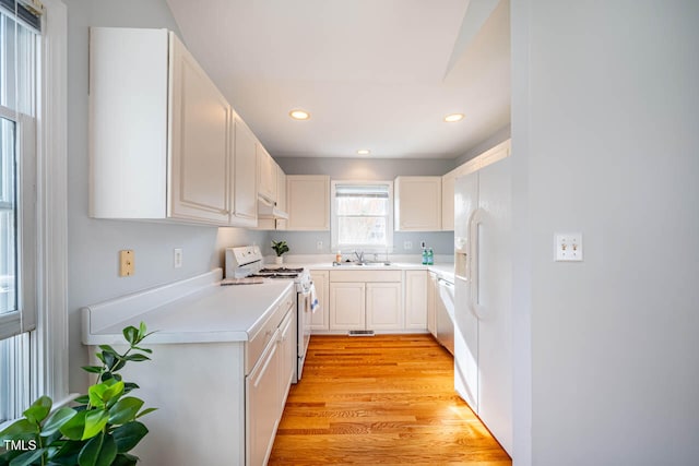 kitchen featuring white cabinetry, light hardwood / wood-style flooring, white appliances, and sink