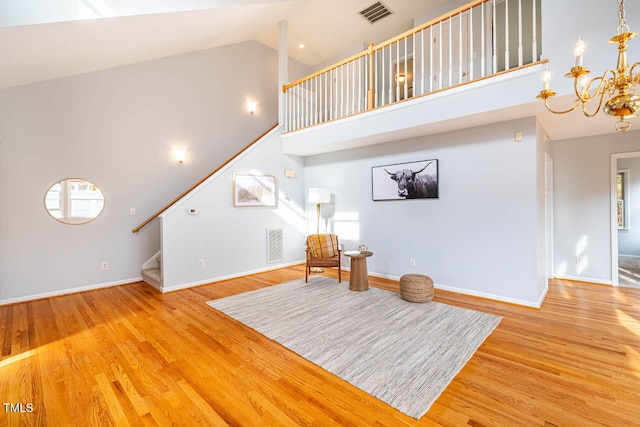 sitting room with high vaulted ceiling, light hardwood / wood-style floors, and an inviting chandelier