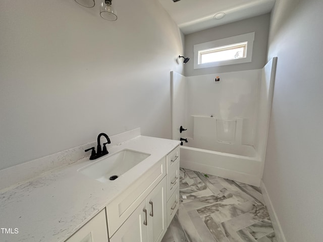 bathroom with marble finish floor, bathtub / shower combination, baseboards, and vanity