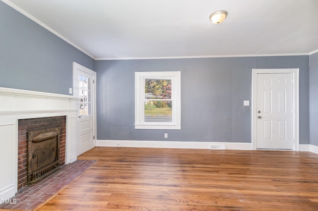 unfurnished living room featuring a fireplace, hardwood / wood-style flooring, and crown molding