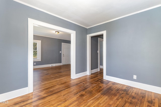 spare room with dark wood-type flooring and ornamental molding