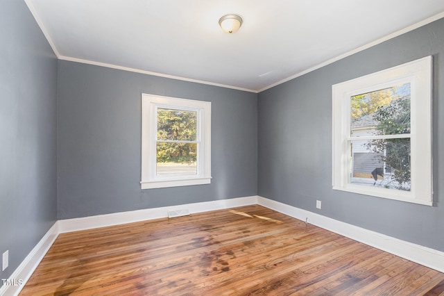 spare room with wood-type flooring and ornamental molding