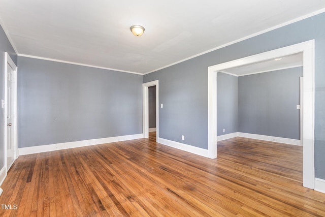 empty room featuring hardwood / wood-style flooring and crown molding