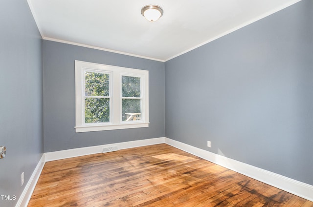 spare room with wood-type flooring and crown molding