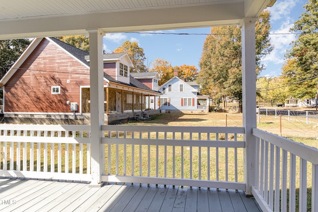 wooden terrace featuring a lawn