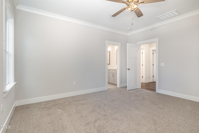 unfurnished bedroom featuring ceiling fan, ornamental molding, ensuite bathroom, and light carpet