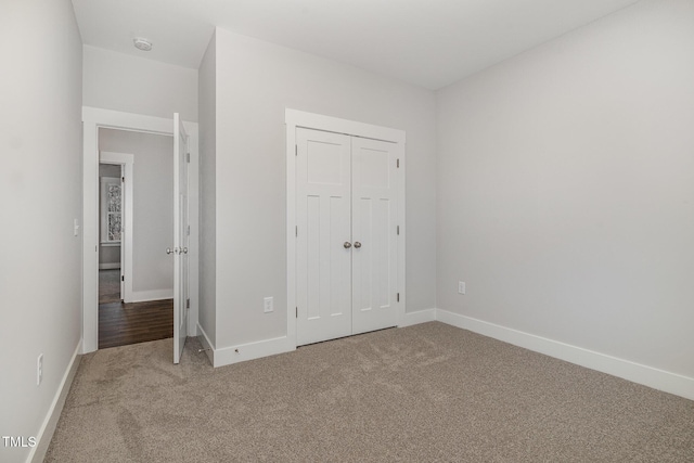 unfurnished bedroom featuring carpet and a closet