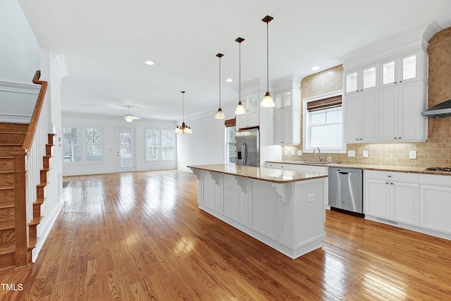 kitchen featuring sink, white cabinetry, a center island, appliances with stainless steel finishes, and a kitchen breakfast bar