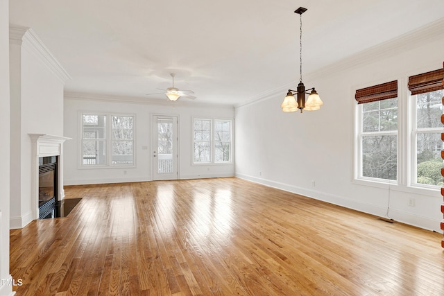 unfurnished living room featuring ornamental molding, plenty of natural light, and light hardwood / wood-style floors