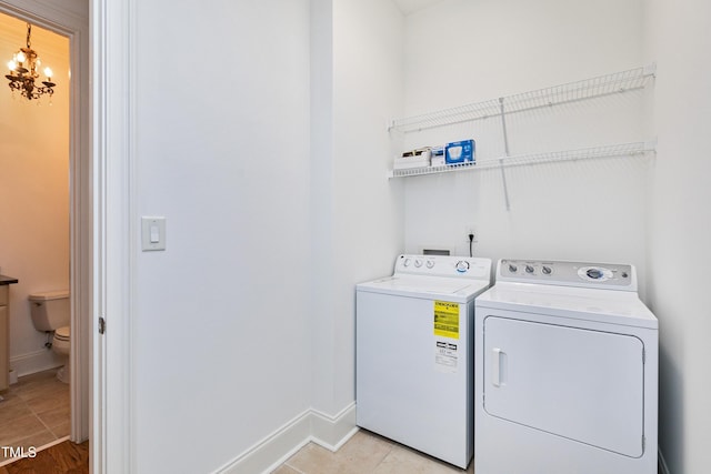 washroom featuring separate washer and dryer, light tile patterned floors, and a chandelier