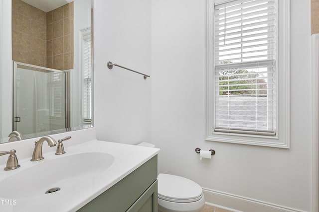 bathroom with vanity, toilet, and a shower with door