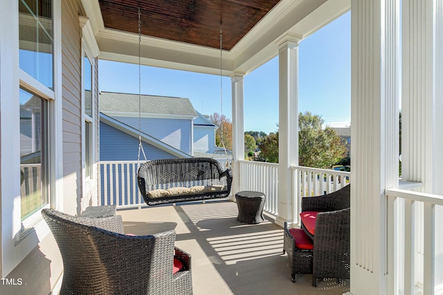 sunroom with wood ceiling, a tray ceiling, and ornate columns